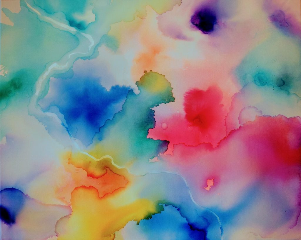 Abstraktní akvarelová malba s jasnými, smíšenými barvami modré, růžové, žluté, červené a fialové. Měkké okraje a splývavé tvary vytvářejí snový, oblačný vzhled s jemnými přechody mezi jednotlivými barvami.